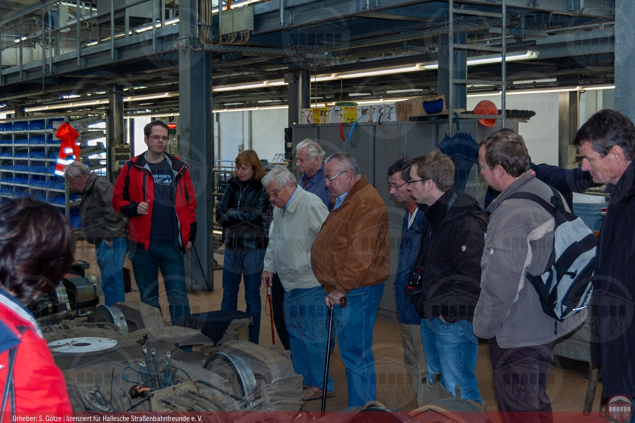 Foto der Teilnehmergruppe im Betriebshof Rosengarten in der Werkstatthalle beim Betrachten eines Drehgestells des Niederflurwagens MGT6D
