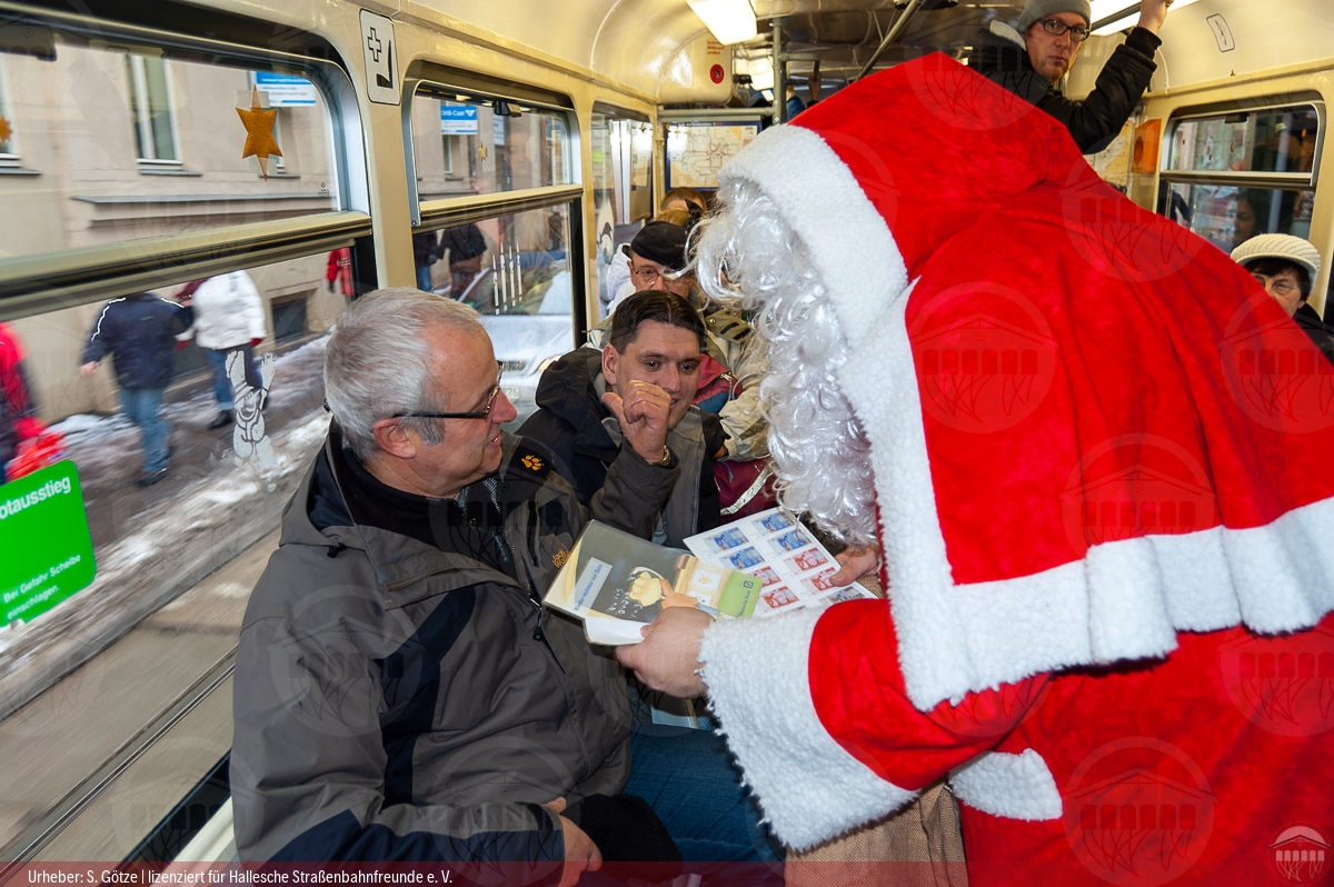 Foto des Weihnachtsmanns im Gespräch mit Fahrgästen im historischen Triebwagen 900